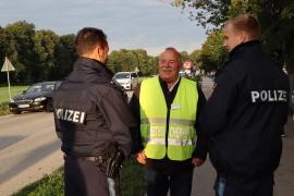 3. Bürgermeister Fritz Botzenhardt und Polizeibeamte waren am ersten Schultag nach den Sommerferien vor der Grundschule Graßlfing anwesend.