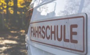 Fahrzeug von hinten mit einem Schild "Fahrschule"
