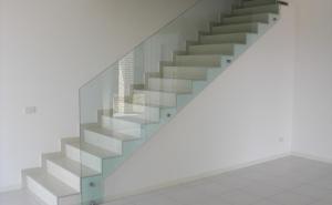 Eine Treppe mit einem Glasgeländer in einem weißen Raum