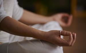 Eine Person in Meditationshaltung mit gekreuzten Beinen