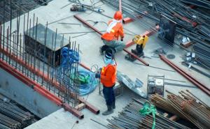 Zwei Bauarbeiter arbeiten auf einer Baustelle.