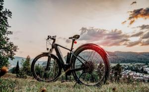 Ein E-Bike steht auf einem Hügel bei Sonnenuntergang.
