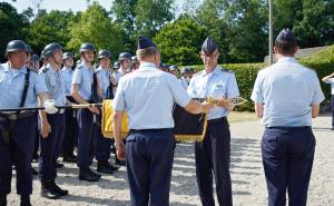 Der Kommandeur der Offizierschule, Brigadegeneral Gero von Fritschen (l.) und Oberstleutnant Andreas Seebörger als bisheriger Lehrgruppenkommandeur rollen gemeinsam die Truppenfahne der II. Lehrgruppe der OSLw in einem feierlichen Akt ein und verhüllen sie anschließend mit einem schwarzen Stoffsack.