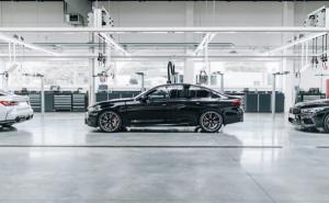 Schwarze Limousine in einer modernen, gut beleuchteten Werkstatt oder Produktionshalle