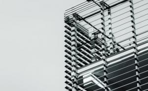 Schwarz-weiß Fotografie einer modernen Gebäudefassade mit horizontalen Stahlstreben.