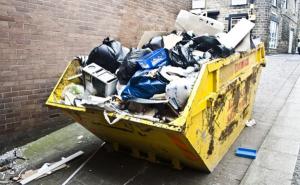 Gelber Müllcontainer, der mit verschiedenen Abfällen gefüllt ist