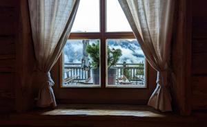 Ein Fenster mit Vorhängen und Blick auf die Berge