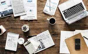 Ein Schreibtisch mit einem geöffneten Laptop und diversen Büroartikeln