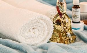 Eine Flasche mit ätherischen Ölen neben Handtüchern