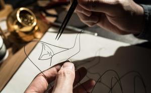 Ein Mann arbeitet an einer Drahtskulptur