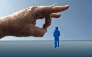 Eine Hand schnippt eine blaue Figur.