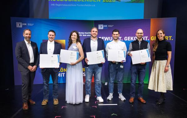 IHK-Abteilungsleiter Florian Kaiser (l.) und IHK-Vizepräsidentin Kathrin Wickenhäuser-Egger (r.) mit Magdalena Braumiller (3. v.l.), Linus Eckl (3 v.r.) sowie deren Ausbildern und Lehrkräften.