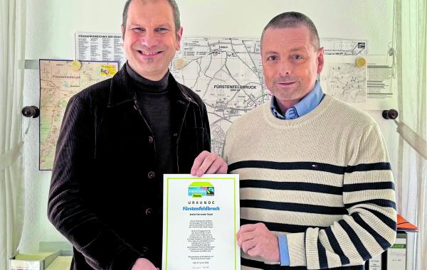 Gemeinsam präsentieren OB Christian Götz (li.) und Hauptamtsleiter Roland Klehr die Urkunde mit der Bestätigung der Auszeichnung „Fairtrade-Stadt“.