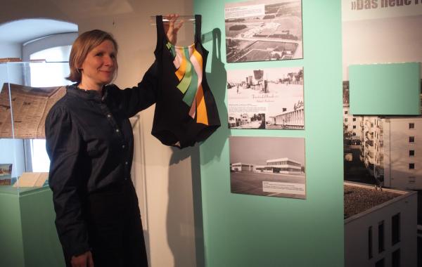 Museumsleiterin zeigt Badeanzug, Ausstellung 5 Orte in FFB, Museum