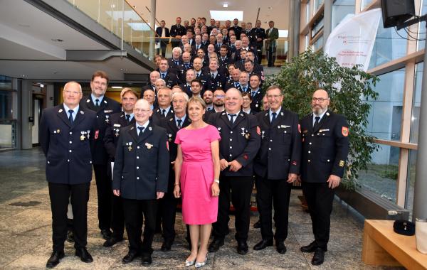 Die geehrten Mitglieder der Feuerwehren des Landkreises Fürstenfeldbruck. Stellvertretende Landrätin Martina Drechsler (vorne Mitte) und Kreisbrandrat Christoph Gasteiger (vorne, ganz rechts) zeichneten sie aus.