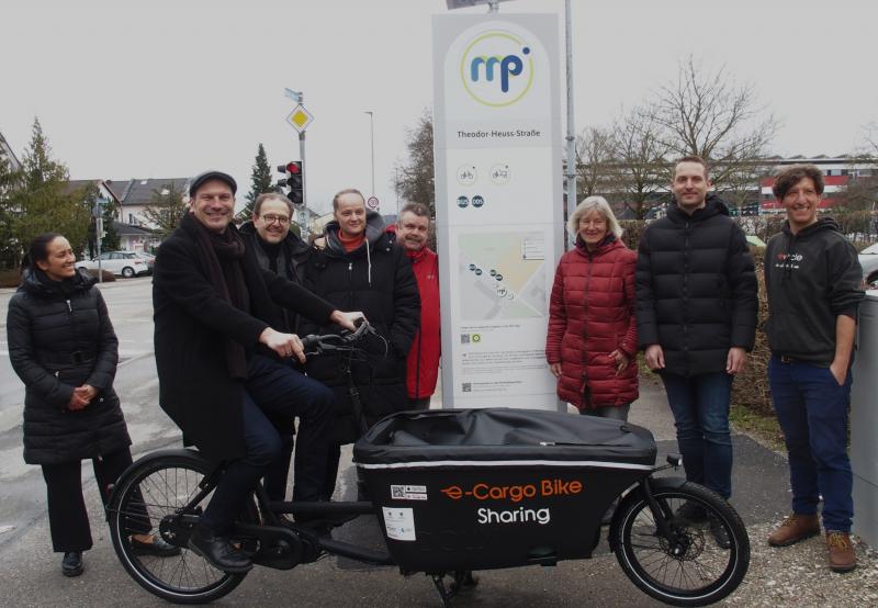Eröffnung des neuen E-Lastenrad Mobilitätspunktes in der Brucker Theodor-Heuss-Straße mit OB Christian Götz auf dem Rad, zusammen mit Projektverantwortlichen und Stadträten. 