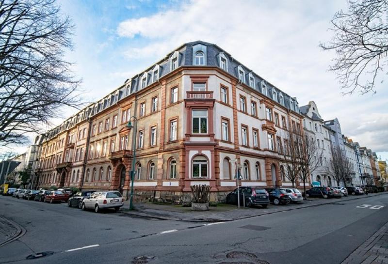 An der Straße gelegenes Altbaugebäude mit vielen Fenstern