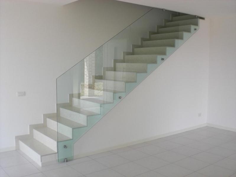 Eine Treppe mit einem Glasgeländer in einem weißen Raum