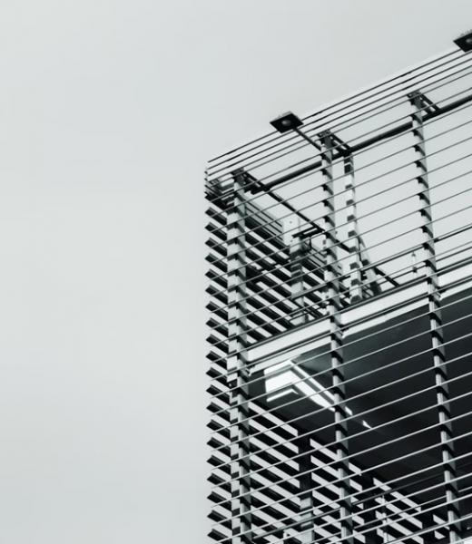 Schwarz-weiß Fotografie einer modernen Gebäudefassade mit horizontalen Stahlstreben.