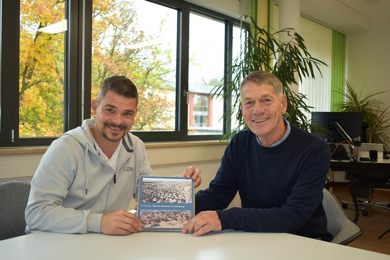 Michael Dörschug (rechts) übergibt Bürgermeister Stefan Floerecke die erste Auflage seines Buches „Reise in die Vorzeit von Emmering“. Während der Entstehung des Werkes standen beide in engem Austausch