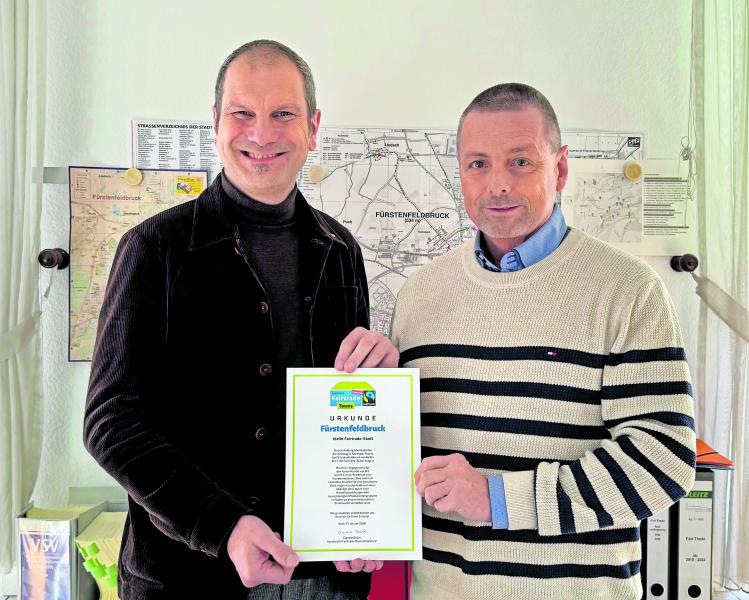 Gemeinsam präsentieren OB Christian Götz (li.) und Hauptamtsleiter Roland Klehr die Urkunde mit der Bestätigung der Auszeichnung „Fairtrade-Stadt“.