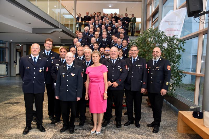 Die geehrten Mitglieder der Feuerwehren des Landkreises Fürstenfeldbruck. Stellvertretende Landrätin Martina Drechsler (vorne Mitte) und Kreisbrandrat Christoph Gasteiger (vorne, ganz rechts) zeichneten sie aus.