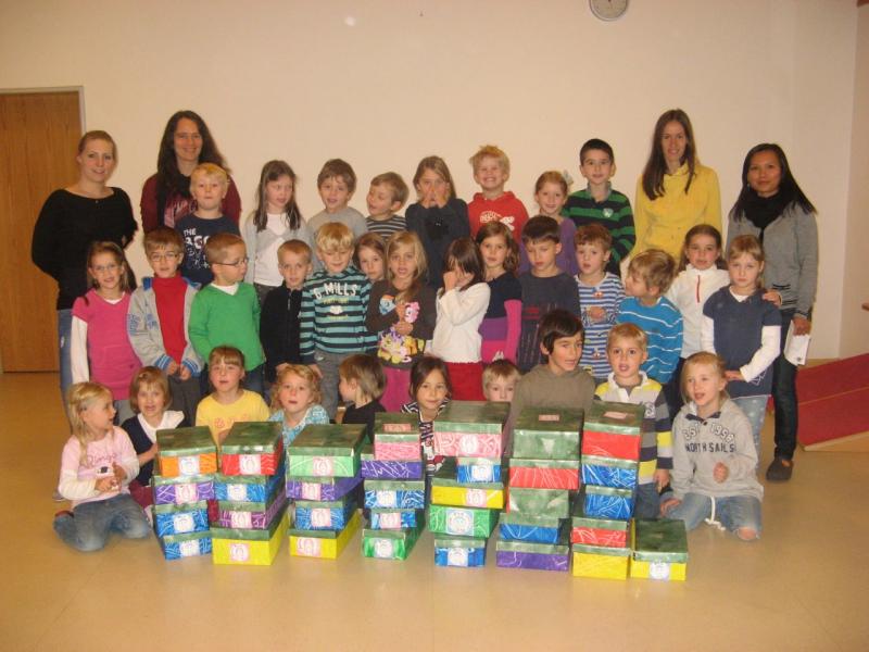 Fleissig und stolz: Die Vorschulkinder des Arche Noah Kindergartens mit ihren 33 selbstgemachten Geschenkartons, begleitet von ihren Erzieherinnen.