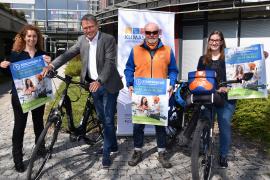 Menschen mit Fahrrad und Plakat.