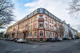 An der Straße gelegenes Altbaugebäude mit vielen Fenstern