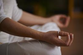 Eine Person in Meditationshaltung mit gekreuzten Beinen