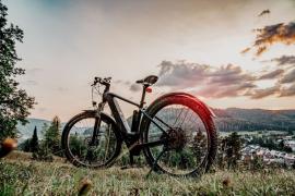 Ein E-Bike steht auf einem Hügel bei Sonnenuntergang.