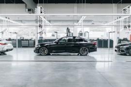 Schwarze Limousine in einer modernen, gut beleuchteten Werkstatt oder Produktionshalle