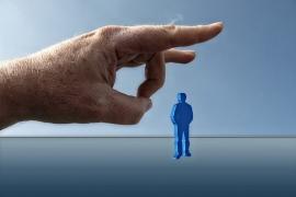 Eine Hand schnippt eine blaue Figur.