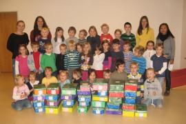 Fleissig und stolz: Die Vorschulkinder des Arche Noah Kindergartens mit ihren 33 selbstgemachten Geschenkartons, begleitet von ihren Erzieherinnen.