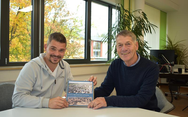 Michael Dörschug (rechts) übergibt Bürgermeister Stefan Floerecke die erste Auflage seines Buches „Reise in die Vorzeit von Emmering“. Während der Entstehung des Werkes standen beide in engem Austausch