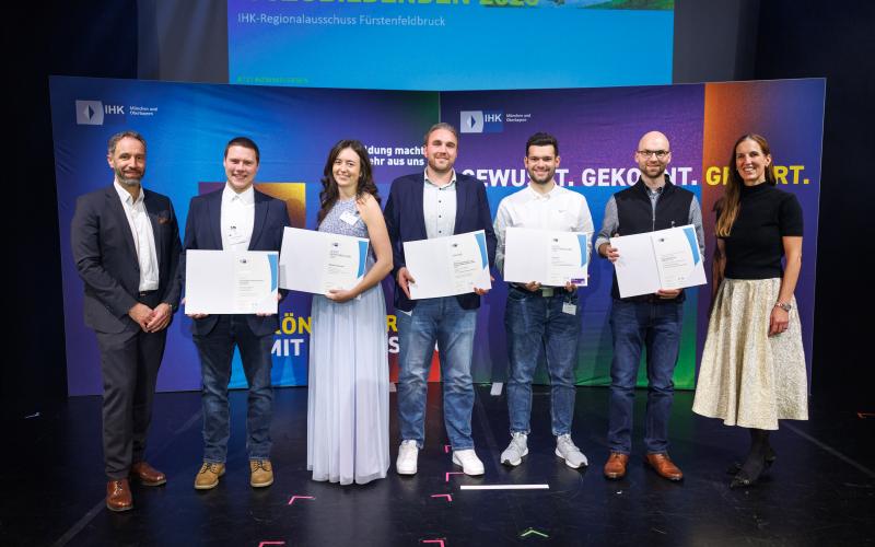 IHK-Abteilungsleiter Florian Kaiser (l.) und IHK-Vizepräsidentin Kathrin Wickenhäuser-Egger (r.) mit Magdalena Braumiller (3. v.l.), Linus Eckl (3 v.r.) sowie deren Ausbildern und Lehrkräften.
