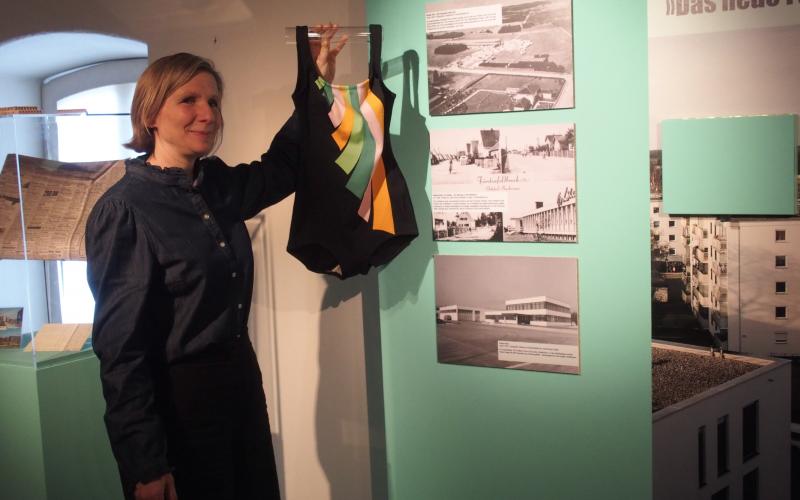 Museumsleiterin zeigt Badeanzug, Ausstellung 5 Orte in FFB, Museum