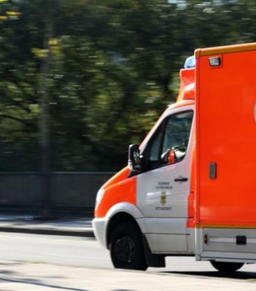 Ein Krankenwagen fährt die Straße entlang.  