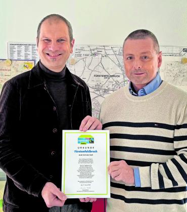Gemeinsam präsentieren OB Christian Götz (li.) und Hauptamtsleiter Roland Klehr die Urkunde mit der Bestätigung der Auszeichnung „Fairtrade-Stadt“.