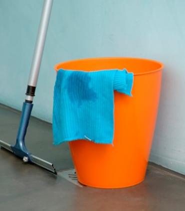 Putzeimer mit Wischer und Reinigungstuch auf einem Boden